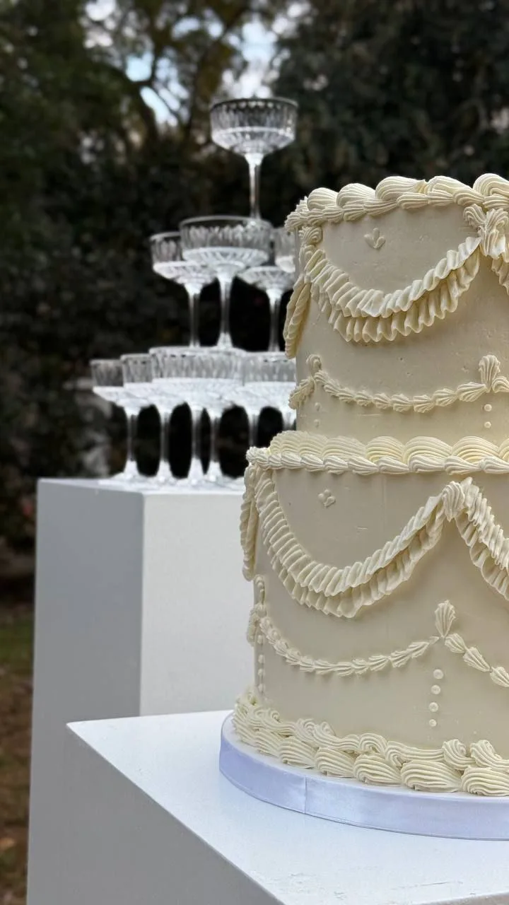 Elegant tiered wedding cake next to a champagne tower at WestWind Estate in Spartanburg SC