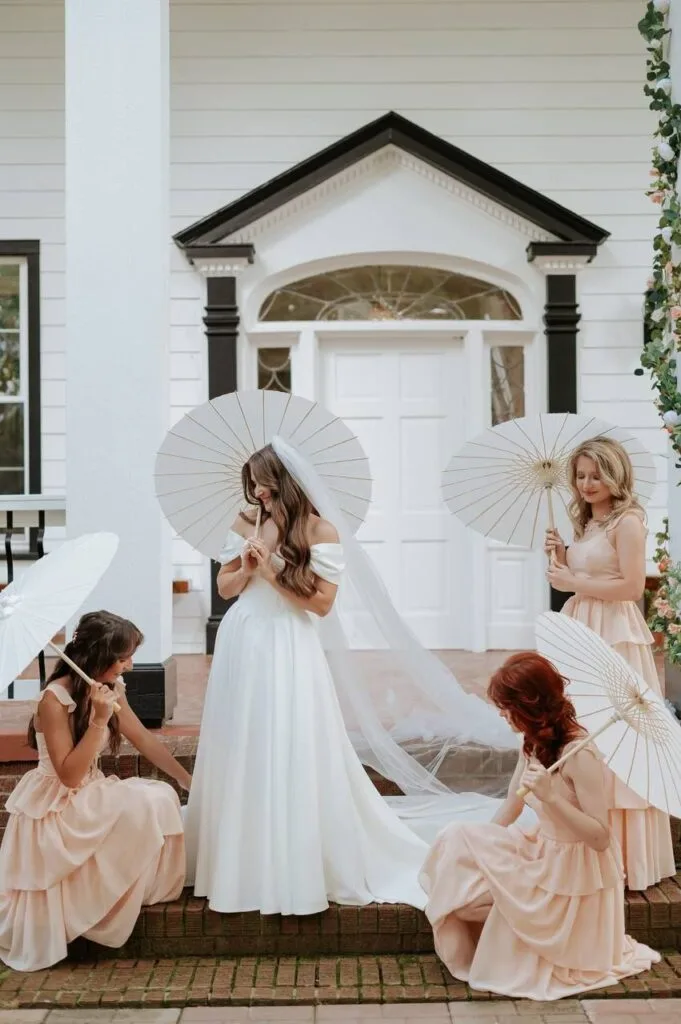 Bridal party with parasols on the porch at WestWind Estate in Spartanburg SC